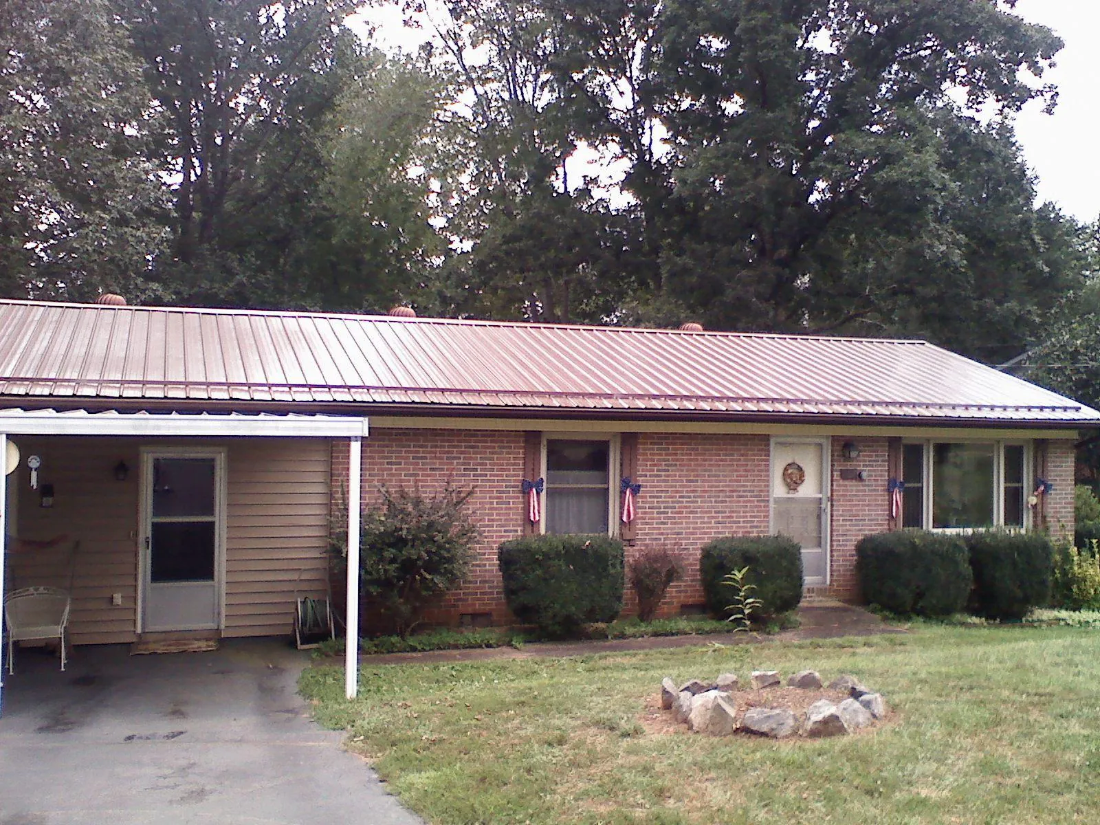 Bronze metal roof and carport on a brick ranch home — Roof Repair work by our crew in Cedar Grove